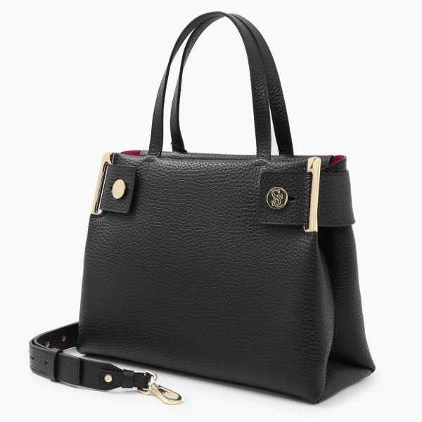 A black leather tote bag with gold-tone metal accents and a brand emblem on the front, accompanied by a detachable strap.