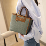 Woman holding a green and brown handbag with a blurred background