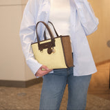 Woman holding a beige handbag with a blurred background